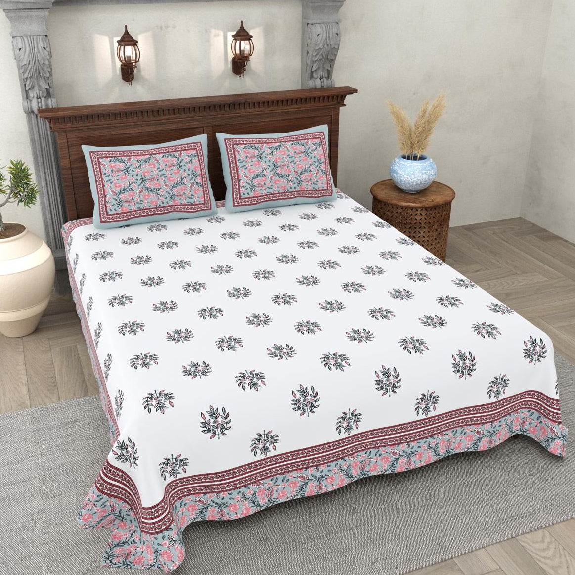 Floral patterned bedspread on a bed in a bedroom setting with decorative elements.