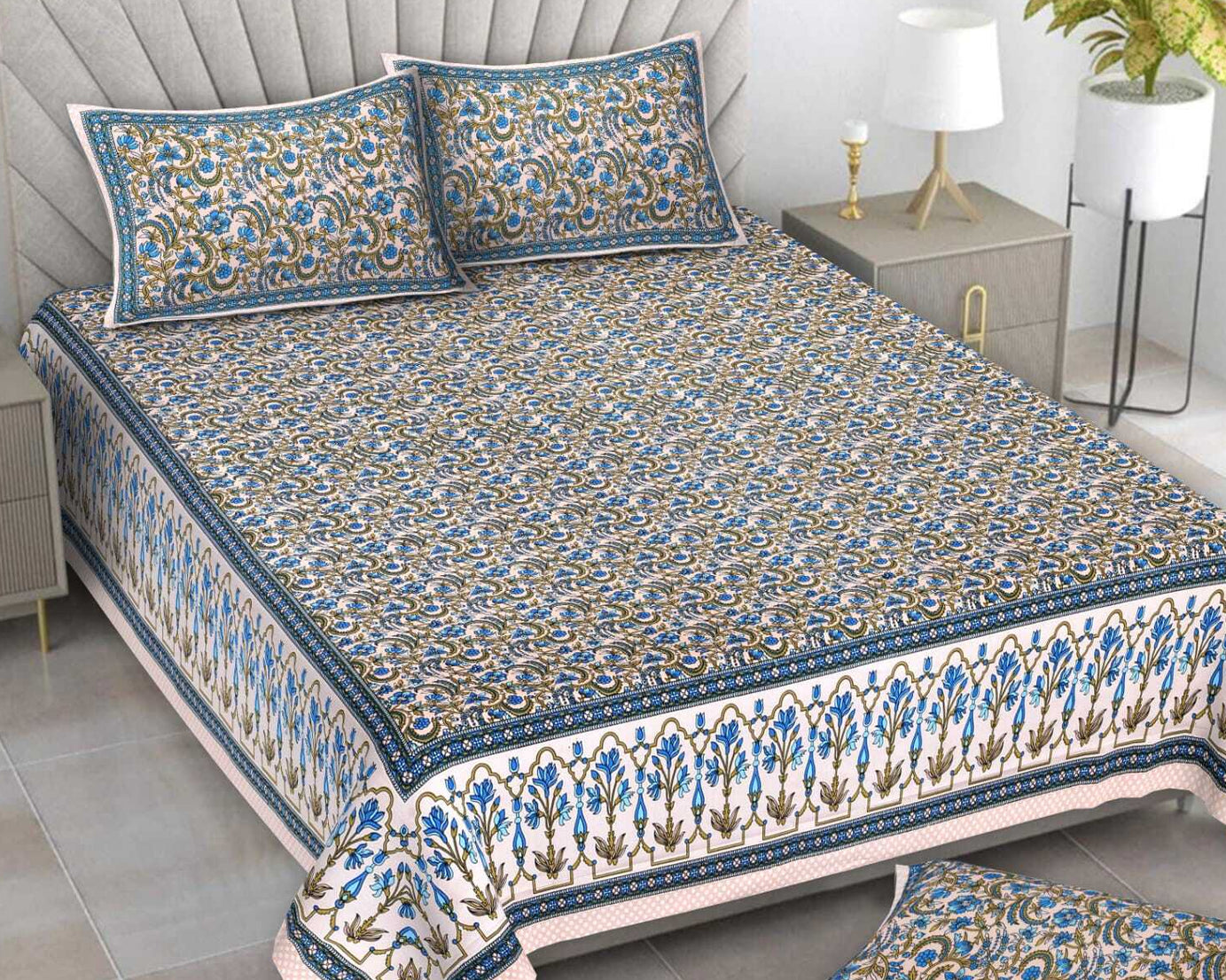Decorative bedspread with floral patterns on a bed in a bedroom setting.