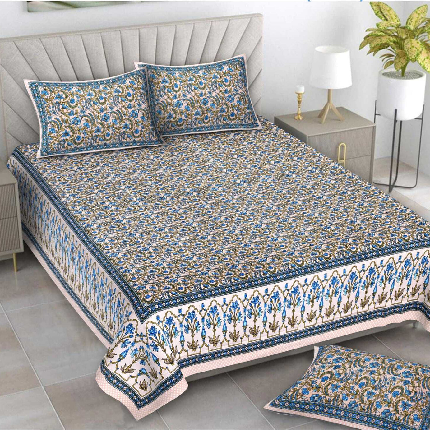 Decorative bedspread with floral patterns on a bed in a bedroom setting.
