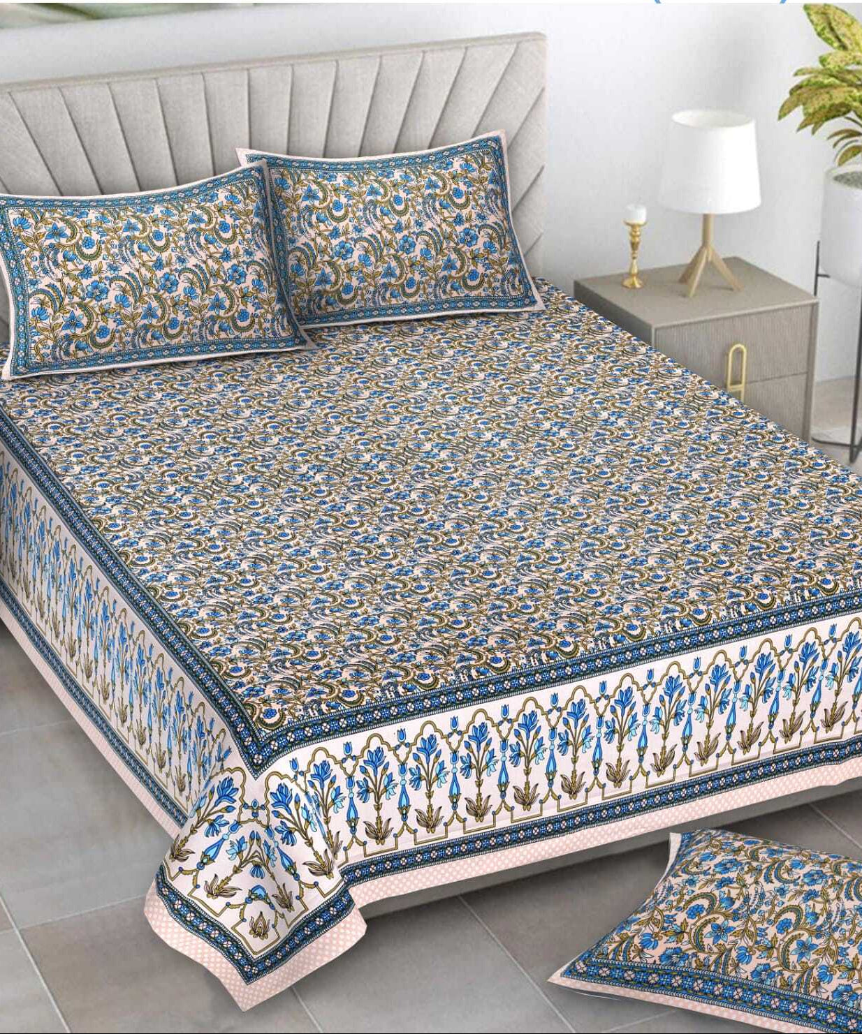 Decorative bedspread with floral patterns on a bed in a bedroom setting.