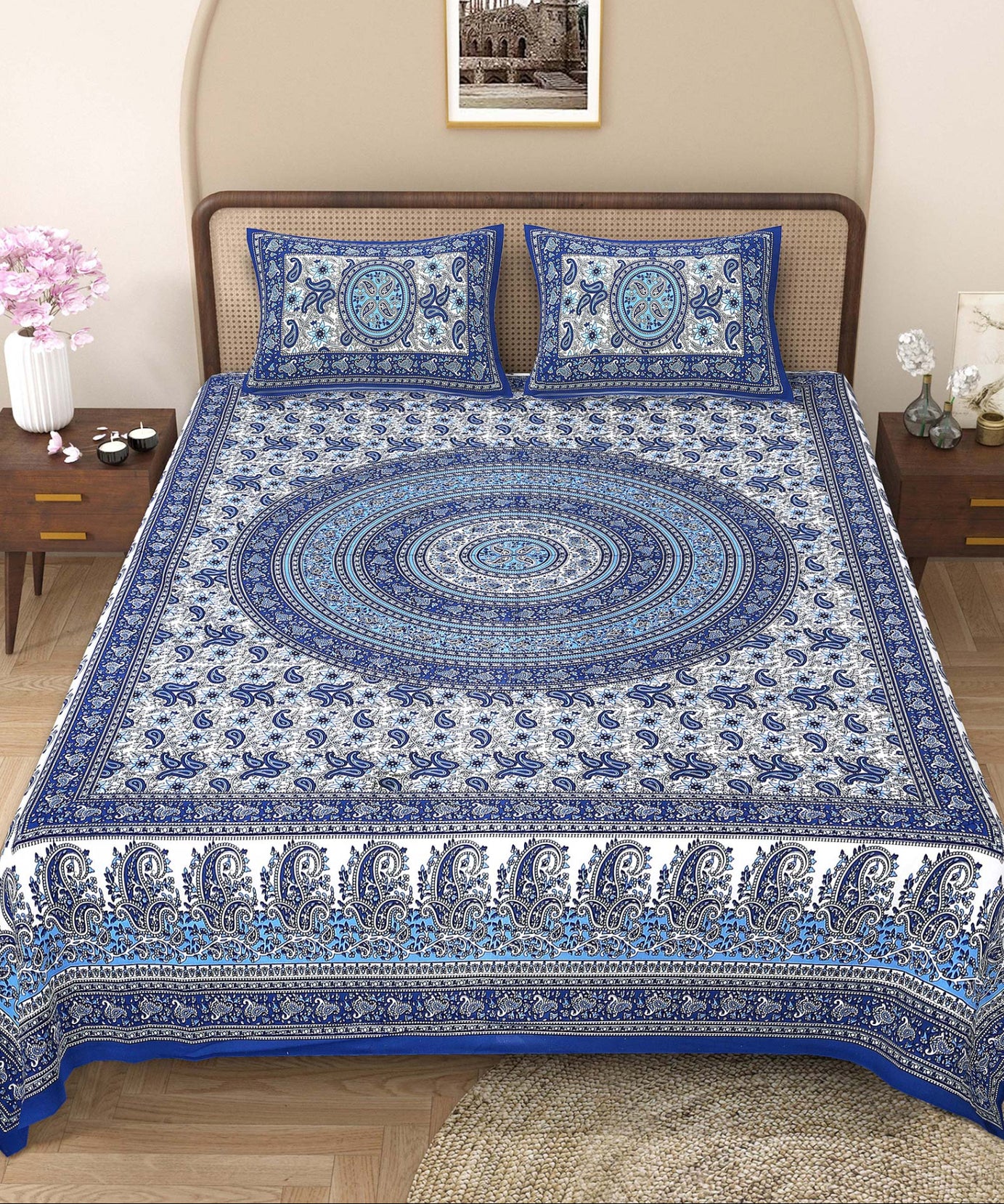 Blue and white patterned bedspread on a bed with matching pillows in a bedroom setting.