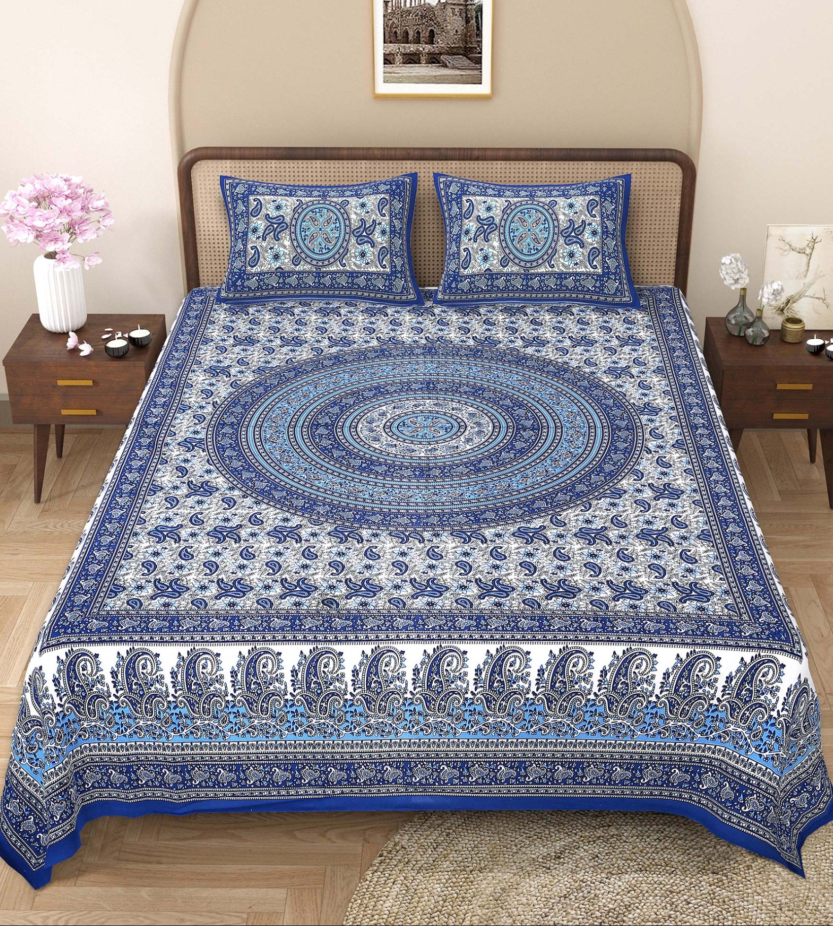 Blue and white patterned bedspread on a bed with matching pillows in a bedroom setting.