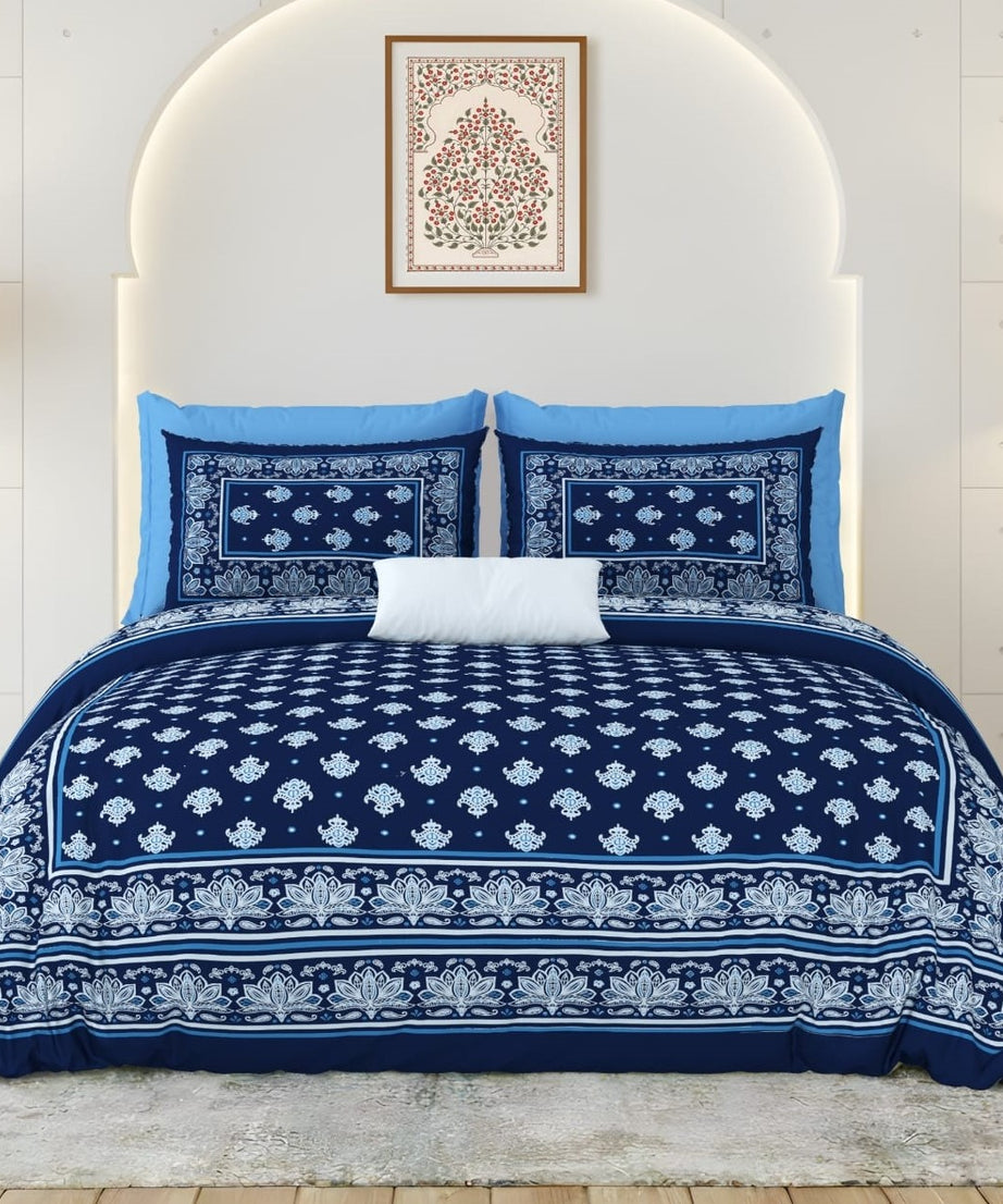 Navy and white patterned bedding set on a bed with a white headboard.