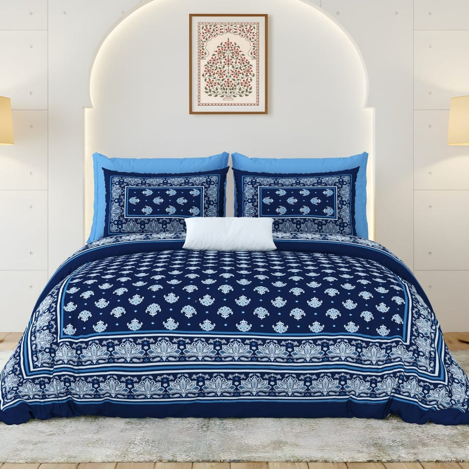 Navy and white patterned bedding set on a bed with a white headboard.