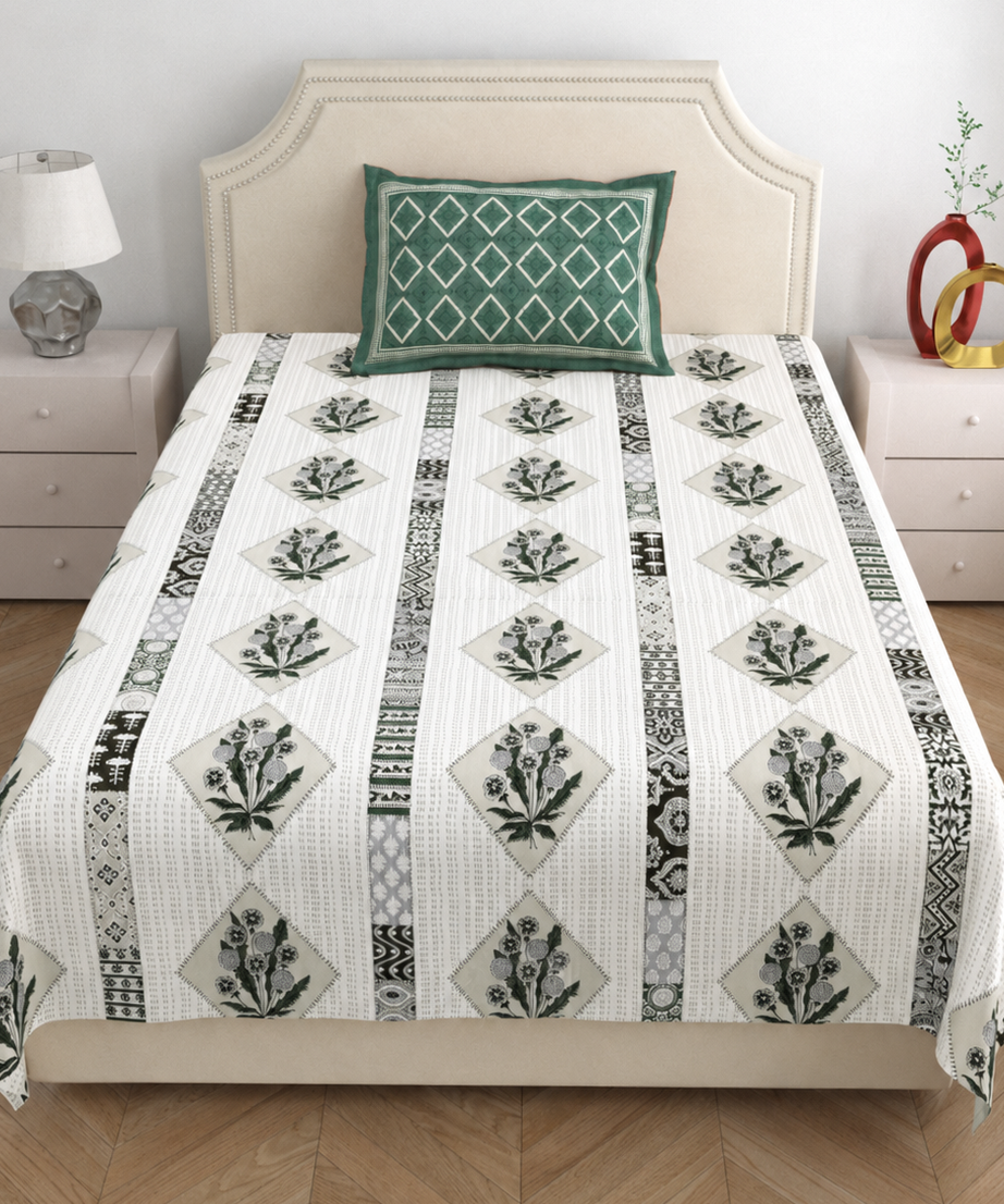 Bed with floral patterned comforter and green pillow in a bedroom setting.