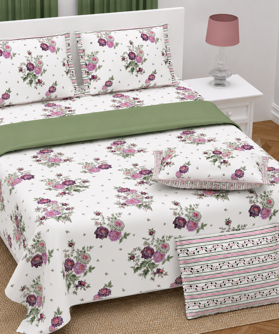 Floral bedding set on a bed with a nightstand and lamp in a bedroom setting.